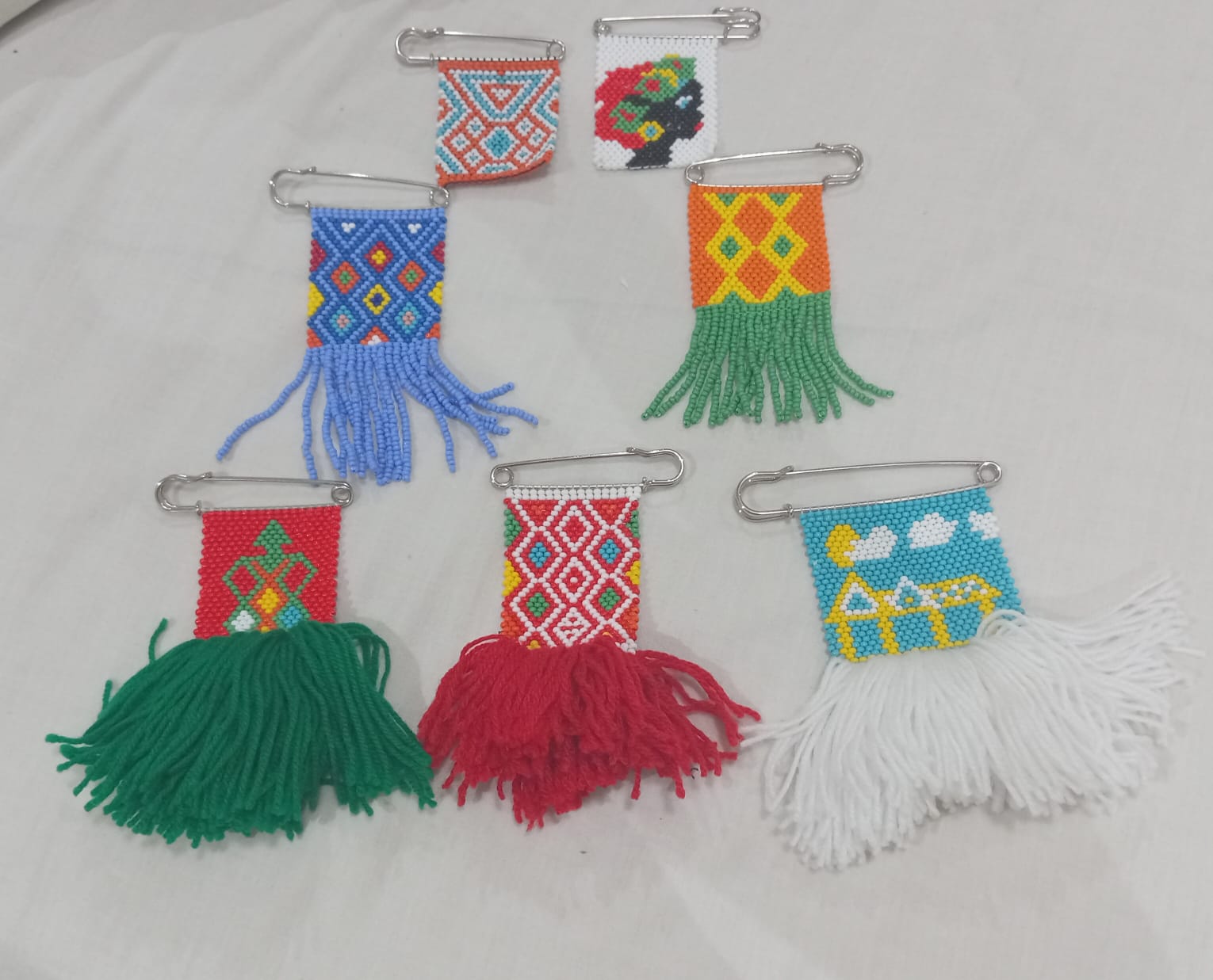 Handcrafted beaded pin badges in traditional patterns